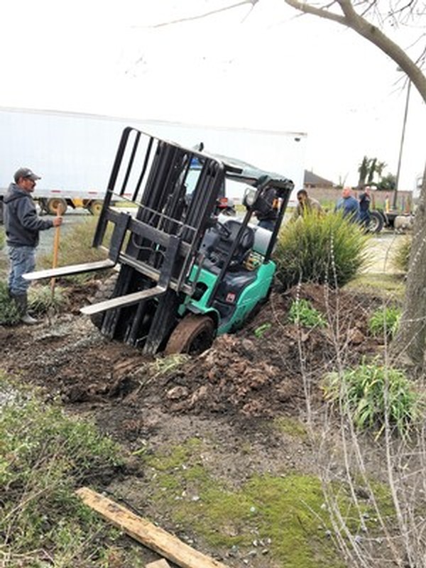 Forklift sunk into the parking lot dirt