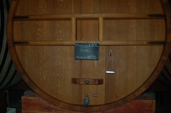 Large wooden barrel filled with fermenting wine